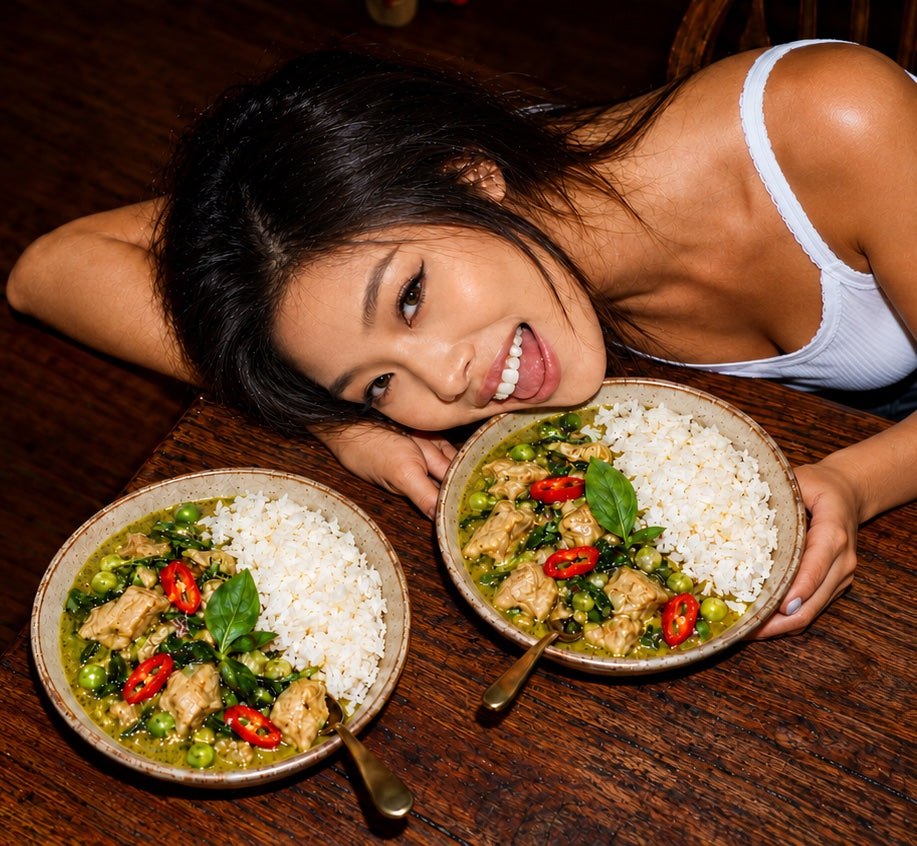A woman resting her head next to two bowls of ITSVA green curry with rice